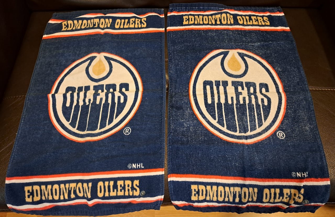 A pair of blue towels featuring the Oilers logo, symbolizing Erlinda Tan's budding passion for NHL hockey during her time in Edmonton.