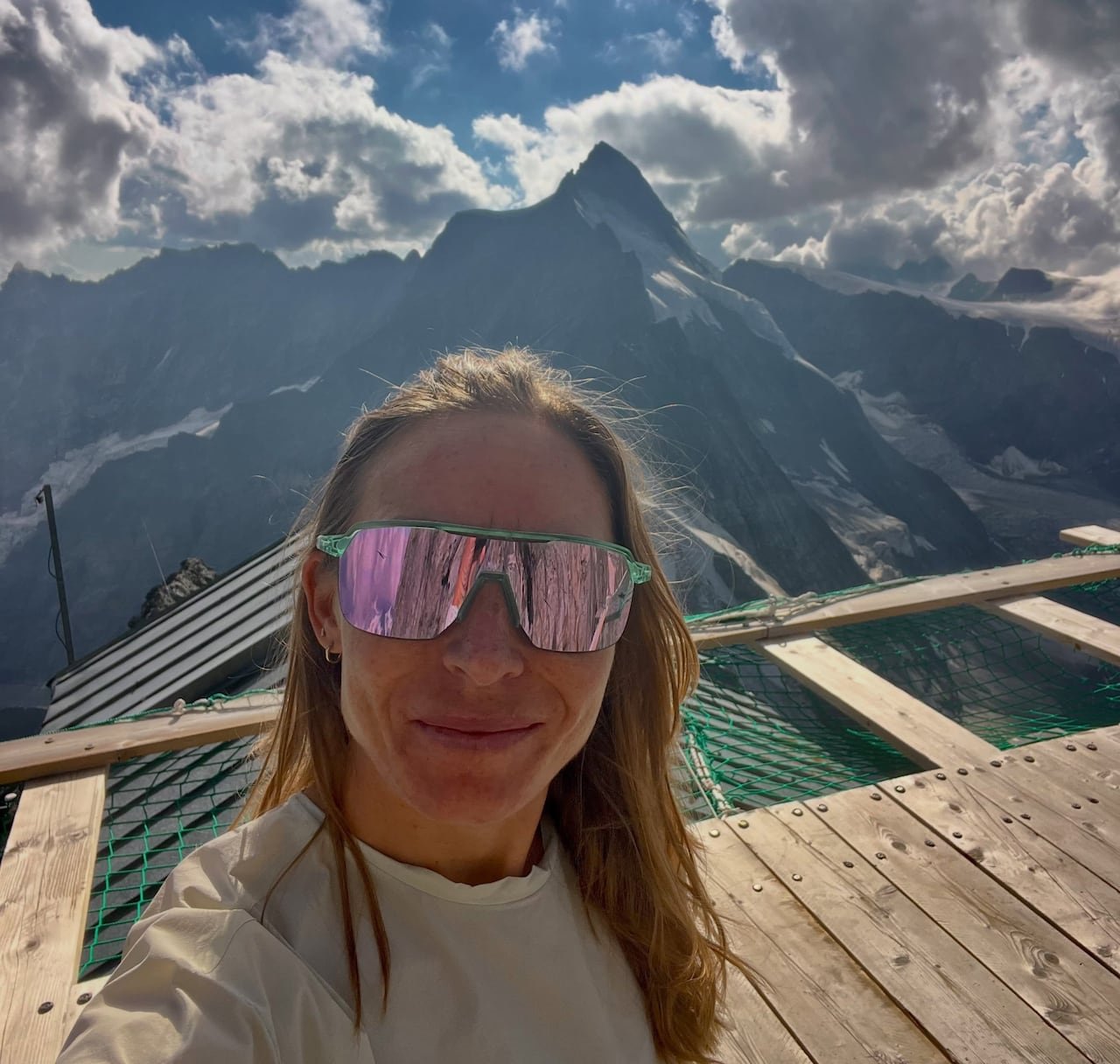 default-672 A woman wearing wraparound sunglasses is seen in front of a mountain.